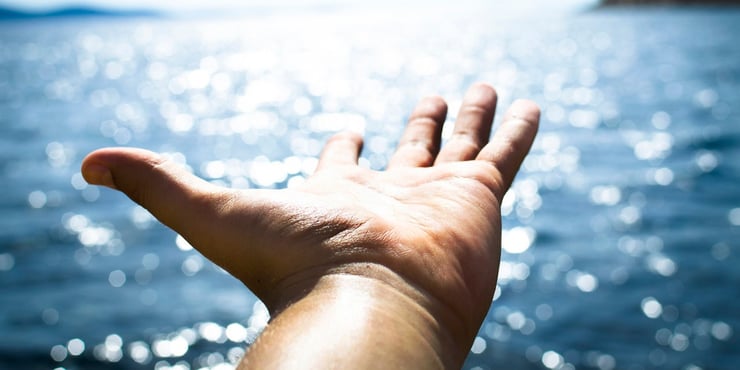 outstretched hand with water in the background, Narrowing Your Focus: The Key to Being a Successful Developer